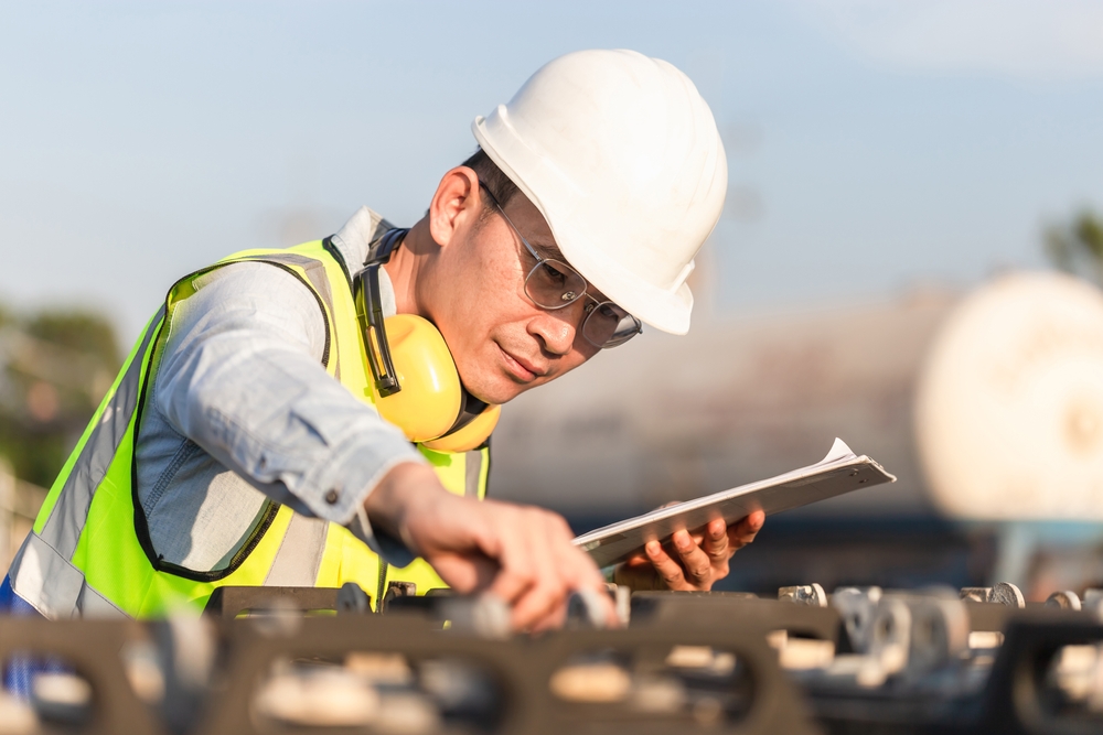 Engineer,In,Waistcoats,And,Hardhats,With,Documents,Inspecting,Construction,Site,